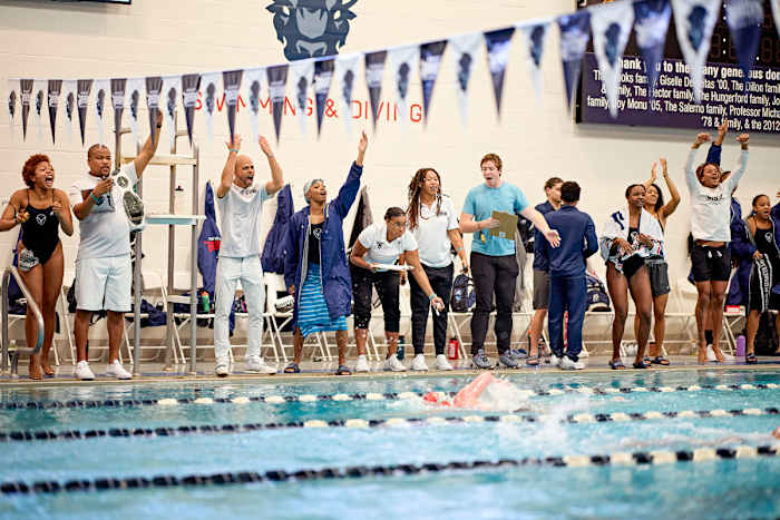 Askew (third from left) urged on his swimmers in an October meet against Mount St. Mary’s. Once chronic losers, the Bison triumphed easily.